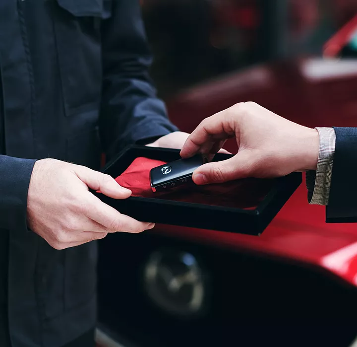 Un mécanicien qui redonne les clés d'un véhicule Mazda au client