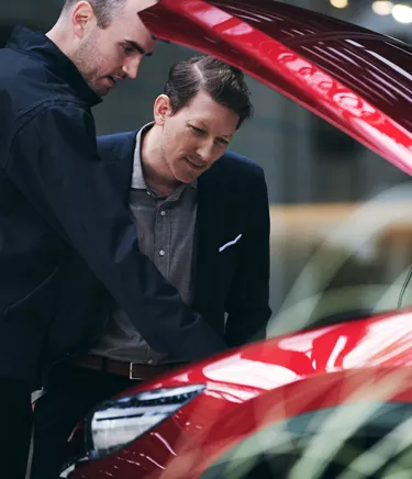 Deux hommes regardant l'intérieur d'un véhicule Mazda
