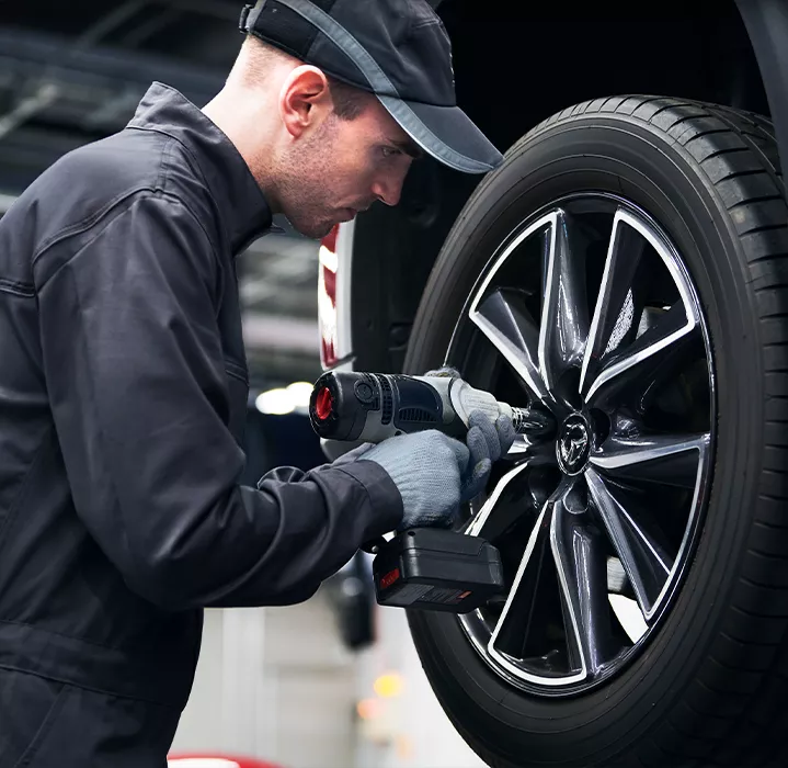 Un mécanicien qui change le pneu d'un véhicule Mazda